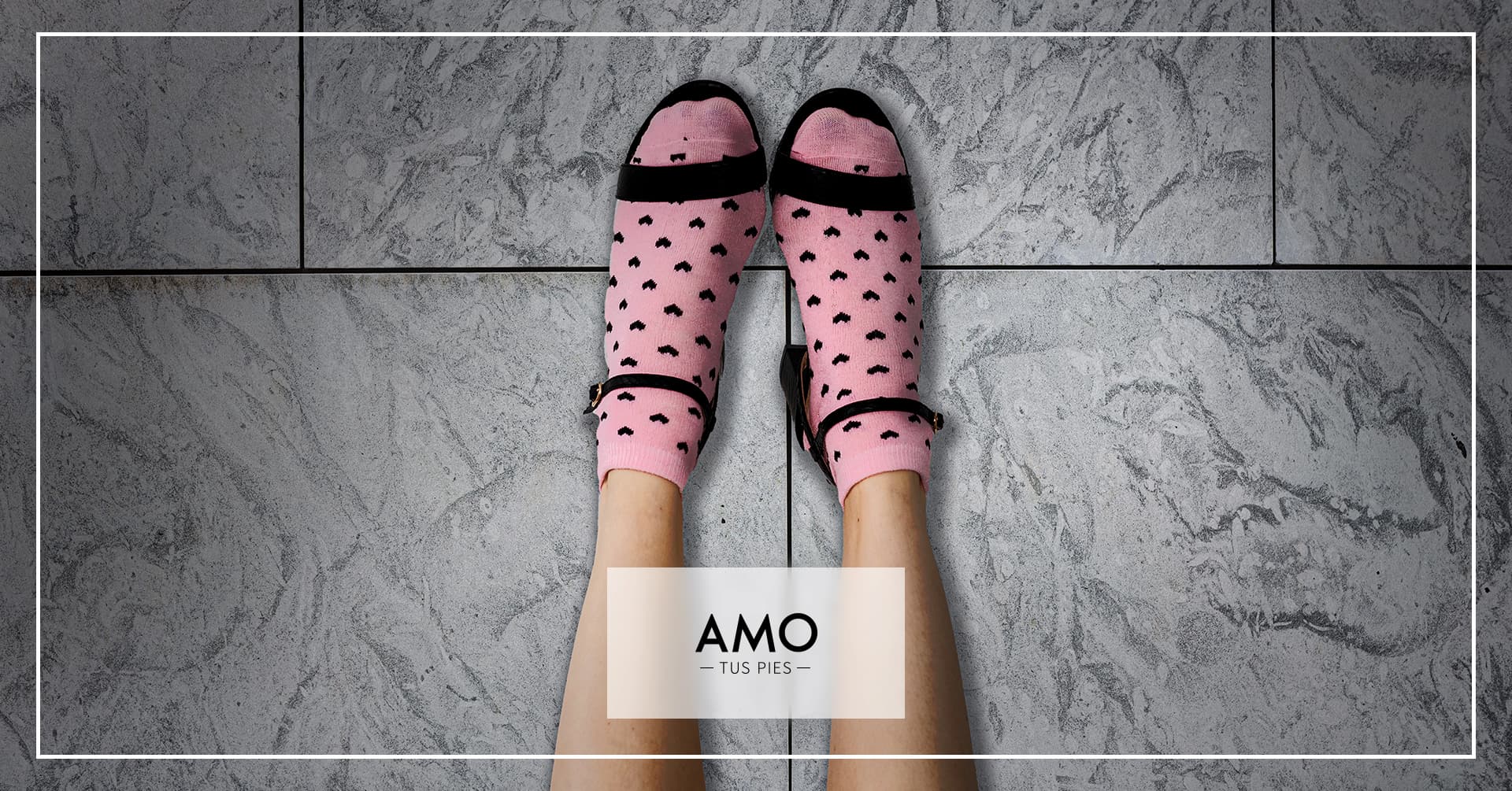 Pies de mujer en sandalias negras con medias de color rosa con corazones negros